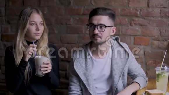 咖啡馆里的女孩和男孩女孩为一个男人干杯视频的预览图