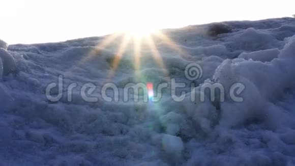 温暖的阳光透过摄像机镜头中覆盖着寒冷的雪山视频的预览图