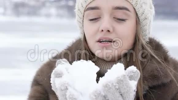美丽的快乐女孩在户外吹雪慢慢地视频的预览图