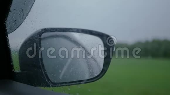 在雨中乘汽车旅行侧窗和汽车镜子上的雨滴下面的动作高清1920x1080视频的预览图