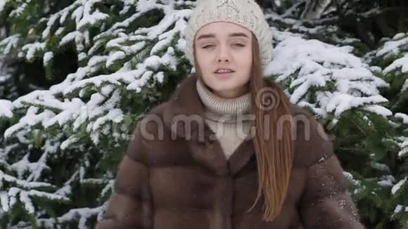 一块雪落在站在树旁的女孩身上慢动作视频的预览图