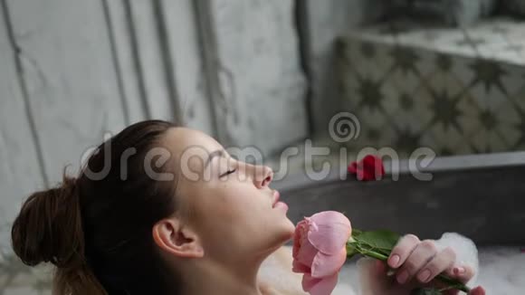 小女孩躺在一个大石头浴缸里手里拿着一朵玫瑰花视频的预览图