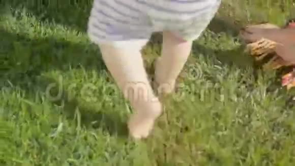 宝宝脚上的特写镜头妈妈在草地上迈出第一步视频的预览图