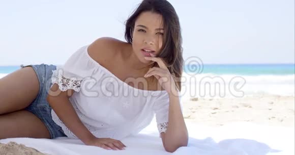 在沙滩伞下放松的漂亮女人视频的预览图