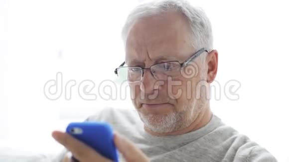 快乐的老人在家打智能手机视频的预览图