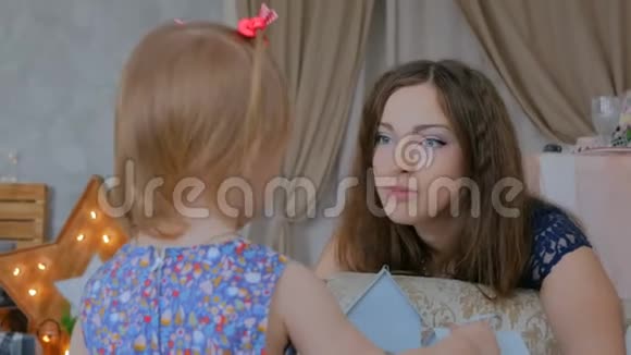 有趣的小女孩和她母亲在家的肖像视频的预览图