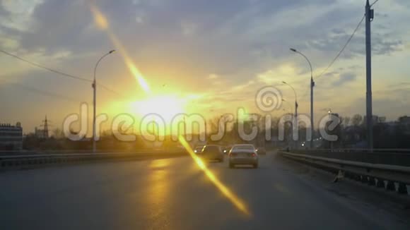 乘坐汽车在城市里对抗美丽的日落效果是镜头和天空高清1920x1080视频的预览图