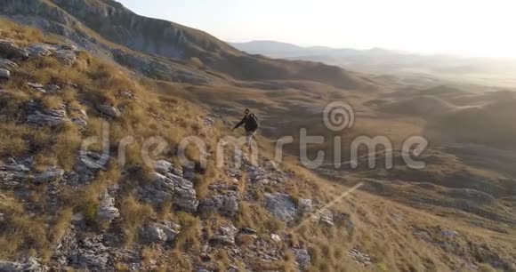 徒步旅行者爬上山坡视频的预览图