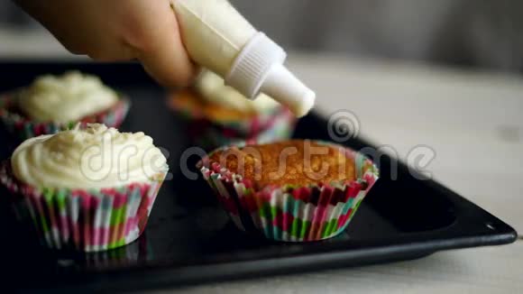 厨师做松饼松饼装饰以鲜奶油装饰的纸杯蛋糕视频的预览图