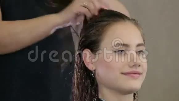 专业的理发师发型师为少女理发做准备视频的预览图