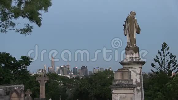 墓碑与圣母玛利亚与黄昏的城市天际线与乌鸦的叫声视频的预览图
