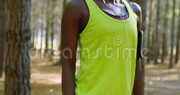 女性慢跑者在森林中伸展4k视频的预览图