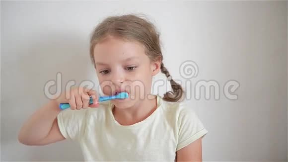 一个小女孩用颜色鲜艳的牙刷刷牙视频的预览图