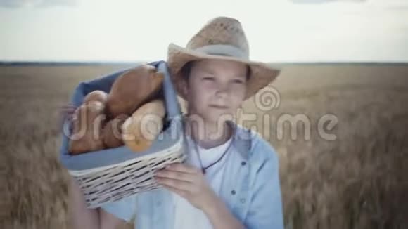 年轻的农民带着面包篮沿着麦田散步视频的预览图
