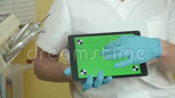牙医拿着一个带有绿色屏幕的平板电脑为你的内容服务视频的预览图