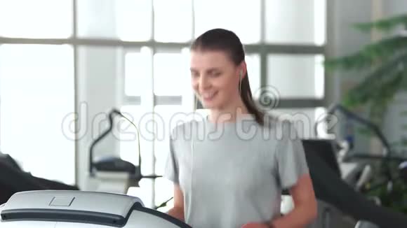 年轻苗条的女人在健身房锻炼视频的预览图