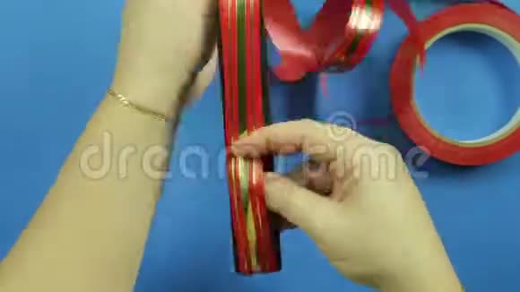 在蓝色背景上做一个红色丝带的礼物蝴蝶结时间跨度视频的预览图