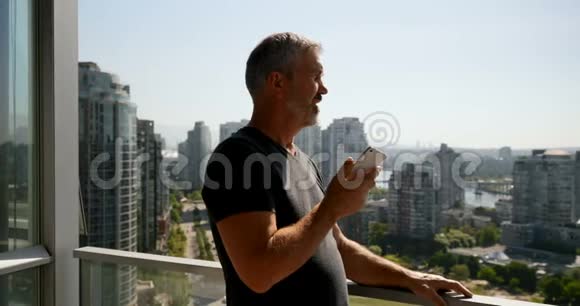 男子在4k阳台上讲手机视频的预览图