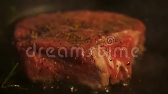 在平底锅上煮肉翻转生牛排特写镜头深色背景视频的预览图