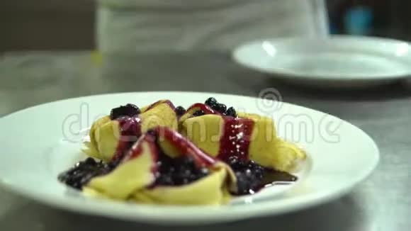 厨房餐厅做饭厨师用蓝莓果酱冰淇淋装饰煎饼视频的预览图