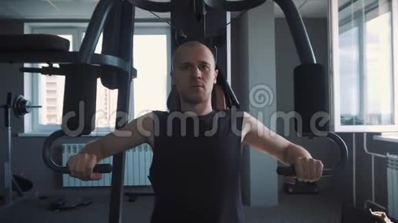 健身室的年轻肌肉男练划艇机视频的预览图