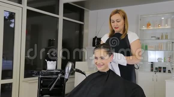 专业的理发师发型师为少女理发做准备视频的预览图