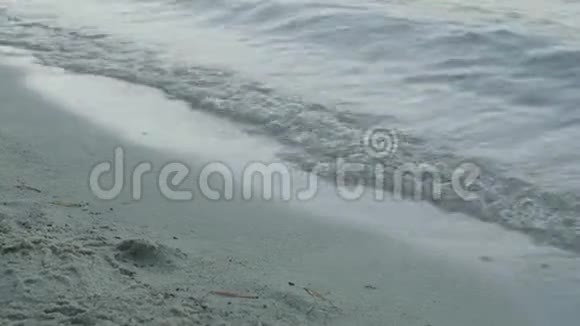 沙滩上的海浪泡沫海浪在海滩冲上岸的特写镜头视频的预览图