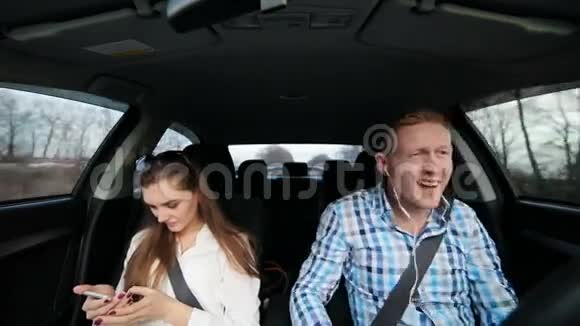 女孩用手机工作车里的人听音乐视频的预览图