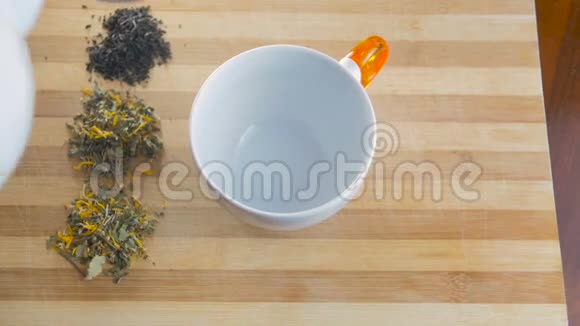 从茶壶里倒茶木制表面上的一杯茶视频的预览图