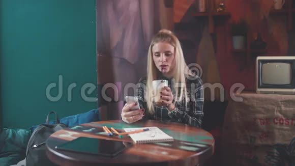 时尚女孩在咖啡店喝咖啡打短信和微笑视频的预览图