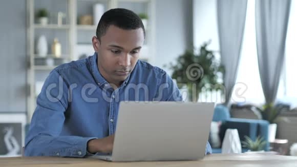 失去沮丧的非洲青年男子在笔记本电脑上工作视频的预览图