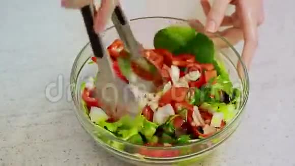 女人的手混合新鲜蔬菜沙拉视频的预览图
