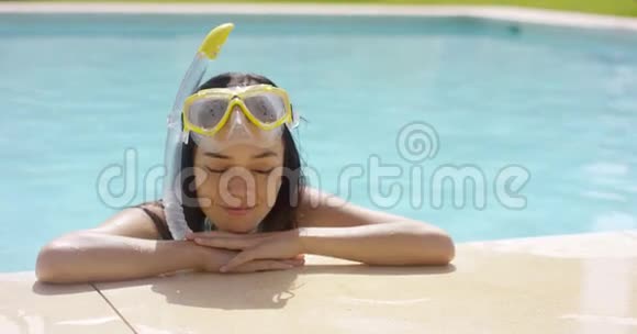 浮潜和护目镜的女人在泳池边休息视频的预览图