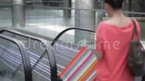 两个女孩在商场的自动扶梯上走下楼梯朋友在商店购物女人在购物视频的预览图