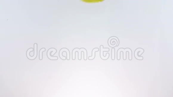 柠檬片水果溅落到白色酒精鸡尾酒和饮水杯中在白色上缓慢地射击视频的预览图