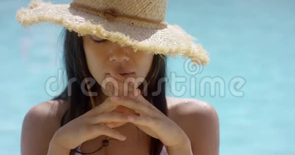 泳池里穿着草帽的浅黑色女郎视频的预览图