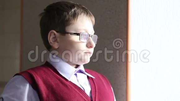 戴眼镜的男孩望着窗外视频的预览图