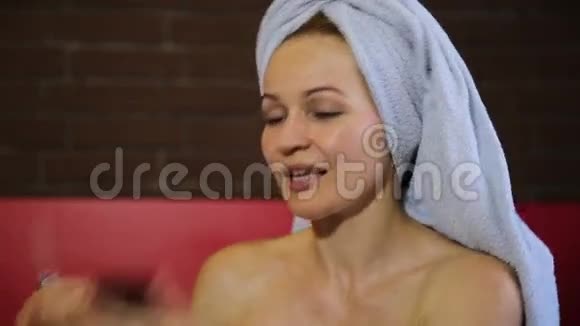 女人穿着浴巾化妆用口红涂嘴唇皮肤护理日常面部皮肤美丽视频的预览图
