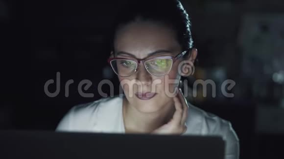 商务女性晚上在办公室工作用眼镜反射电脑屏幕视频的预览图
