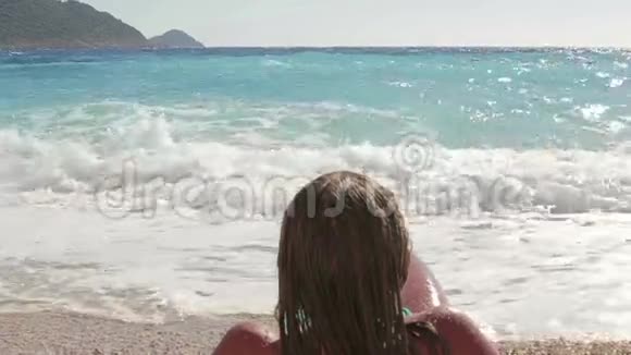 美丽的女孩在海岸边享受阳光和大海视频的预览图