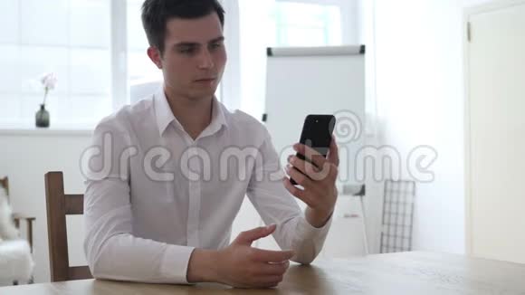 男人在办公室用智能手机自拍视频的预览图