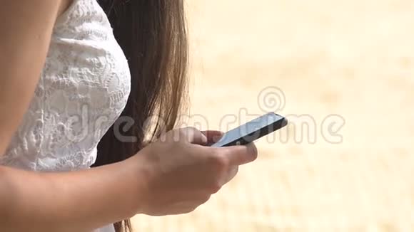 智能手机女性在海滩旅游假期的社交媒体应用程序上发短信查看屏幕上的短信阅读视频的预览图