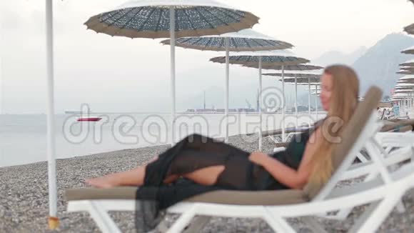 海滩上的女人躺在沙滩上享受大海视频的预览图