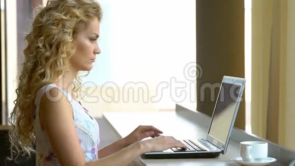 年轻的商务女性在咖啡馆里用笔记本电脑工作视频的预览图