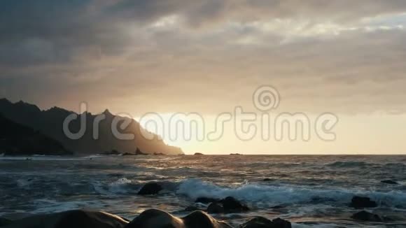 在加那利群岛的特内里费海浪撞击岩石在美丽的夕阳光中喷射视频的预览图