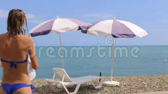 女人在加勒比海海滩上放松有太阳伞和床视频的预览图