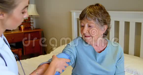 医生在4k床上检查老年妇女的血压视频的预览图