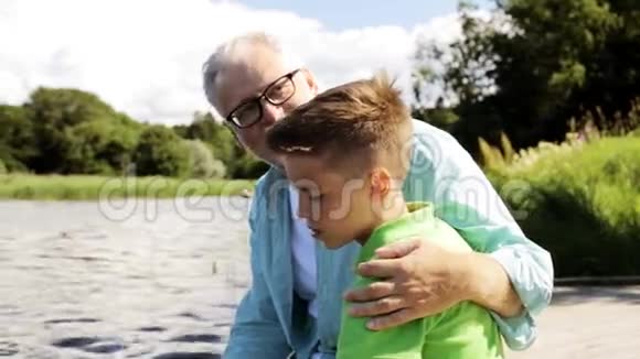 祖父和孙子坐在河泊25号视频的预览图