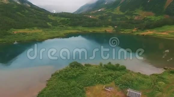 湖中山的倒影美丽的绿松石湖和穿过绿色森林视频的预览图