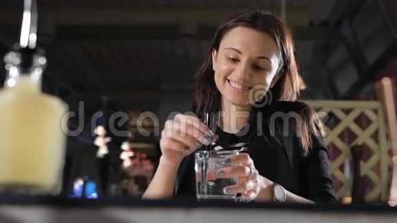 给女孩的苏打水酒保把冰筒放进玻璃杯里视频的预览图